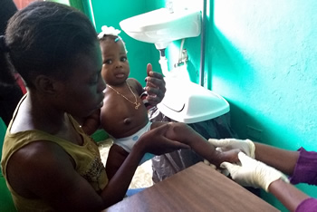 Mom helps doc examine toddler's foot infection.